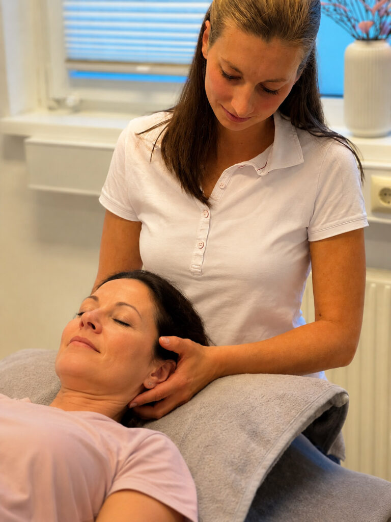 Physiotherapeutin behandelt Patientin bei der Halswirbelsäule