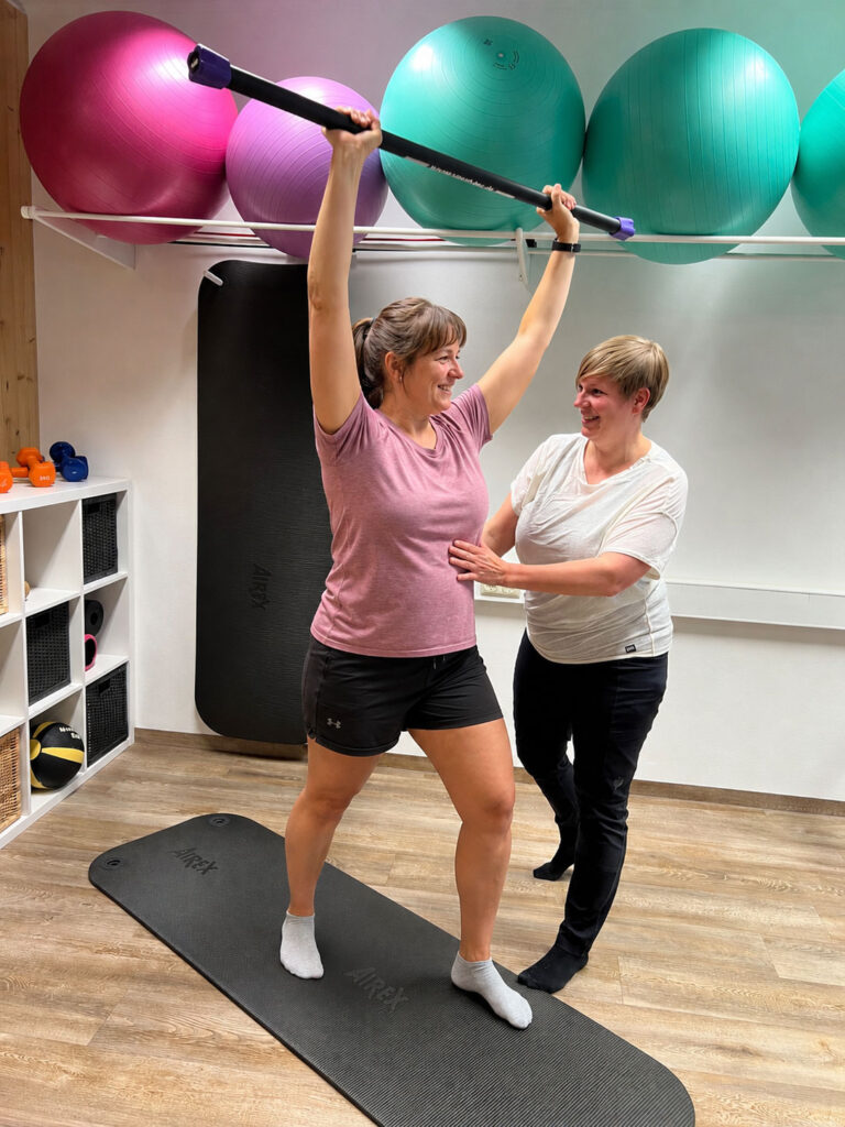 Physiotherapeutin und Patientin bei Physiotherapie zur Rückbildung